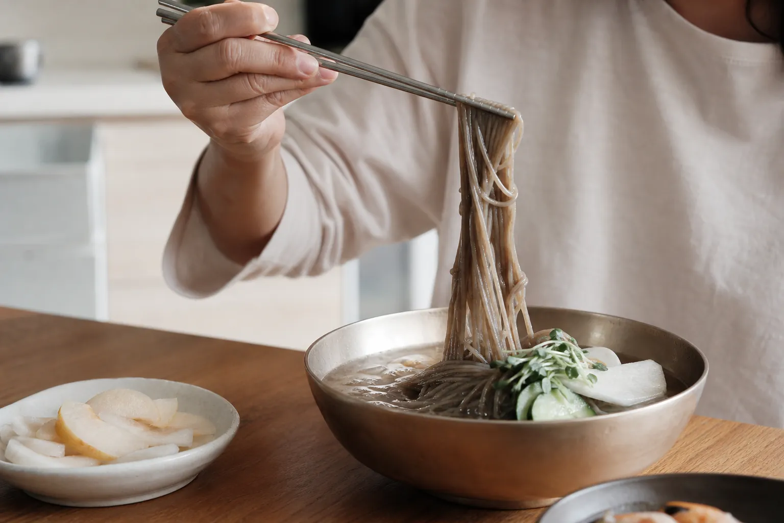 메밀 냉면 면발을 젓가락으로 들어 올리는 모습